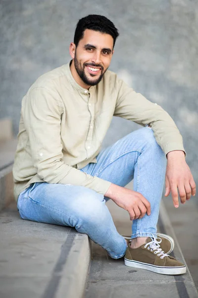 Kendinden Emin Orta Doğulu Bir Gencin Portresi Merdivenlerde Oturuyor Gülümsüyor — Stok fotoğraf