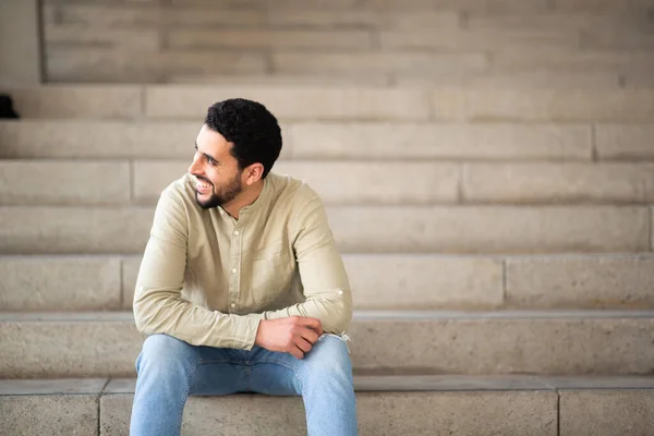 Retrato Jovem Homem Árabe Sorridente Sentado Degraus Olhando Para Longe — Fotografia de Stock
