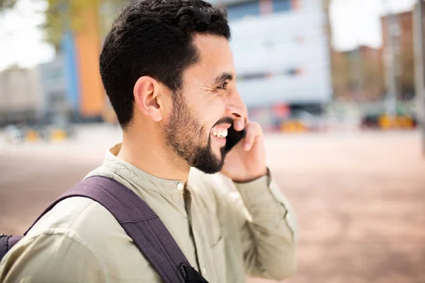 バッグで外を歩く笑顔のアラブ男のクローズアップ側の肖像 電話をかける — ストック写真