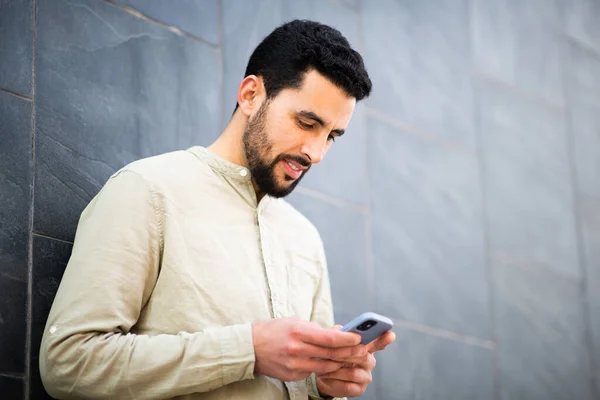Портрет Красивого Молодого Араба Использующего Мобильный Телефон Прислоненный Стене — стоковое фото