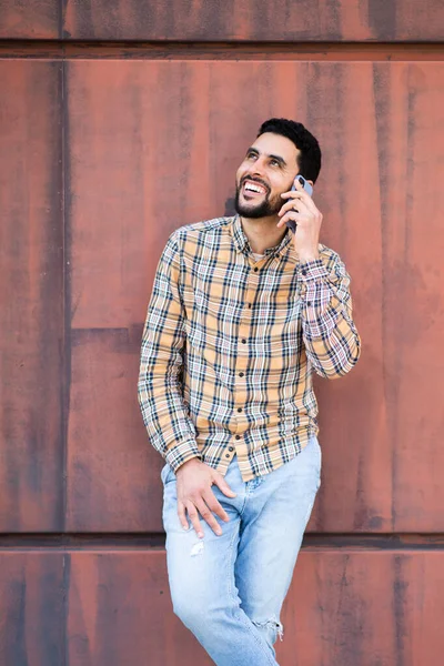 Portrait Stylish Young Arabic Man Talking Mobile Phone Brown Wall — Stock Photo, Image