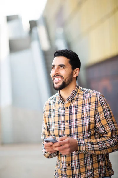 携帯電話で外を歩くハンサムな若いアラブ人の男の肖像 — ストック写真