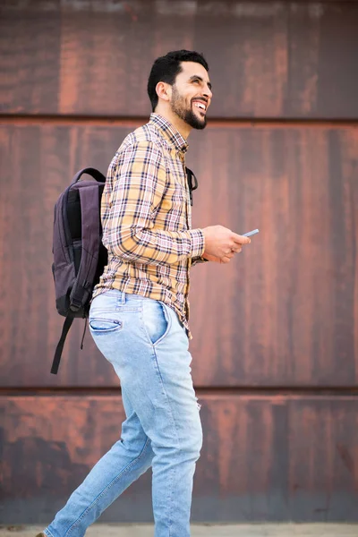 Boczny Portret Wesołego Młodego Arabskiego Faceta Spacerującego Zewnątrz Torbą Telefonem — Zdjęcie stockowe