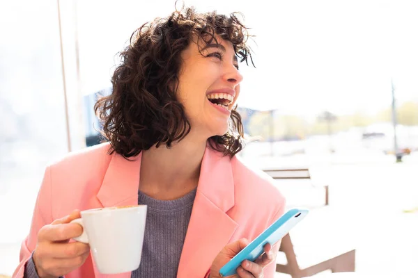 Porträtt Glad Ung Kvinna Med Telefon Som Har Kaffe Sitter — Stockfoto