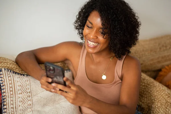 自宅で携帯電話を使用して若い笑顔の女性の肖像画 — ストック写真
