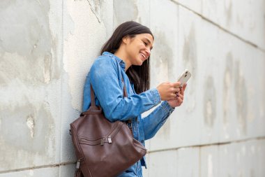 Cep telefonu kullanan gülümseyen bir kadın.