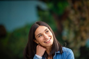 Gülümseyen genç bir kadının yakın portresi.