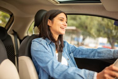 Araba süren gülümseyen genç kadın portresi