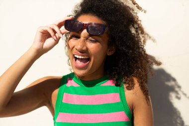 Beyaz duvarda göz kırpan mutlu genç bir kadın portresi