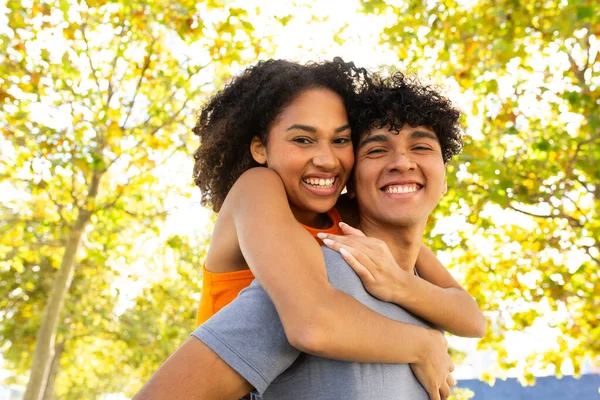 Portrait of young cheerful couple piggyback ride outdoor