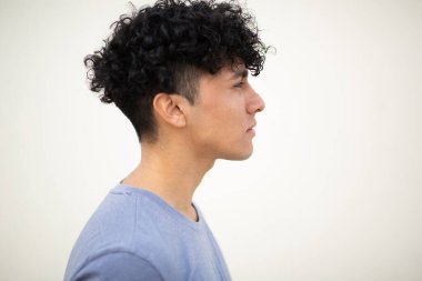 Beyaz arka planda kıvırcık saçlı genç adam profili