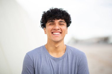 Ön portre mutlu genç adam gülümsüyor.