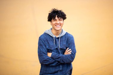 Kollarını kavuşturmuş gülümseyen genç adam portresi