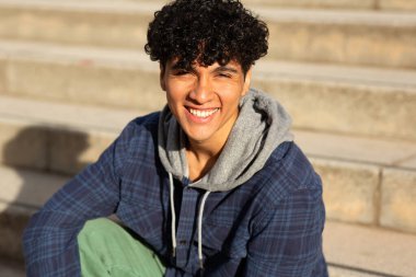 Kapalı portre. Kıvırcık saçlı, gülümseyen yakışıklı adam.