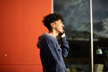 Cep telefonuyla konuşan genç adamın profil portresi