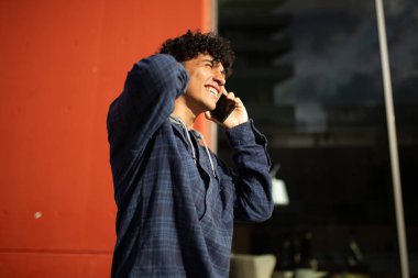 Cep telefonuyla konuşan neşeli genç adam portresi