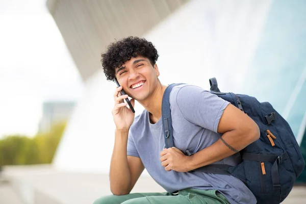 携帯電話で話すバッグを持つ若い男を笑顔にする肖像画 — ストック写真