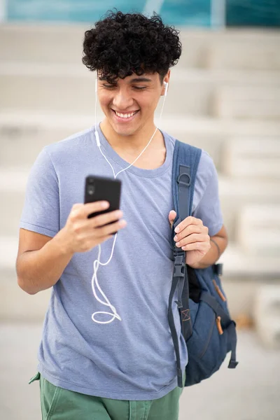 Portrait smiling handsome man with bag looking at cellphone