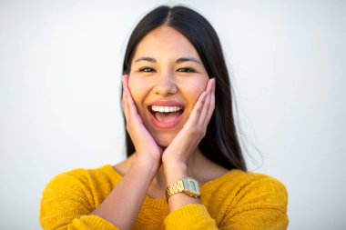 Kapalı portre. Güzel, gülen, yüzü beyaz duvarda genç bir kadın.