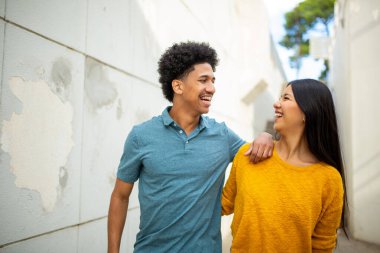 Portre mutlu ve şık Latin çift yürüyor.