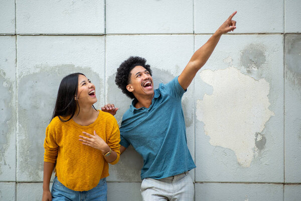 Портрет счастливая молодая пара указывает пальцем