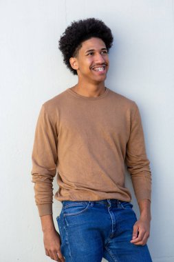 Beyaz duvarın yanında gevşemiş duran mutlu İspanyol adam.