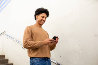 Portre genç İspanyol adam cep telefonuna bakıyor.