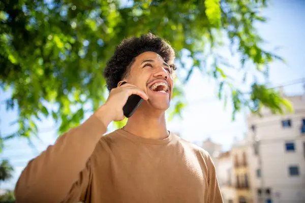Portrait young laughing man talking with mobile phone