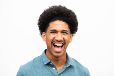 Yüzünde mutlu bir ifade olan Afrikalı Amerikalı genç bir adamın yakın portresi.