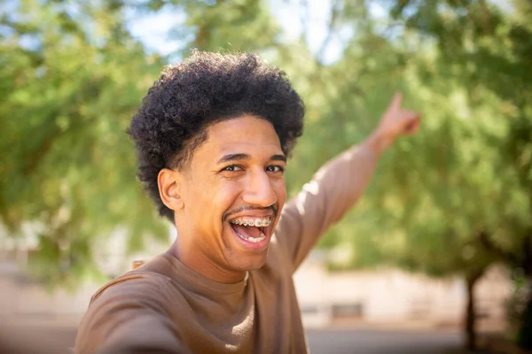 Pria Muda Yang Bahagia Mengambil Foto Selfie Dan Menunjuk Latar — Stok Foto