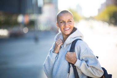 Kel kafalı ve çantalı gülümseyen kadın portresi