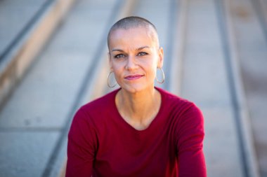 Kafası tıraşlı bir kadının yakın portresi.