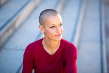 Kafası tıraşlı bir kadının portresi gözlerini kaçırıyor.