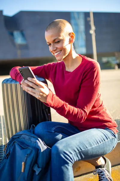 バッグと街に座っている間 携帯電話を見ている笑顔の女性の肖像 — ストック写真