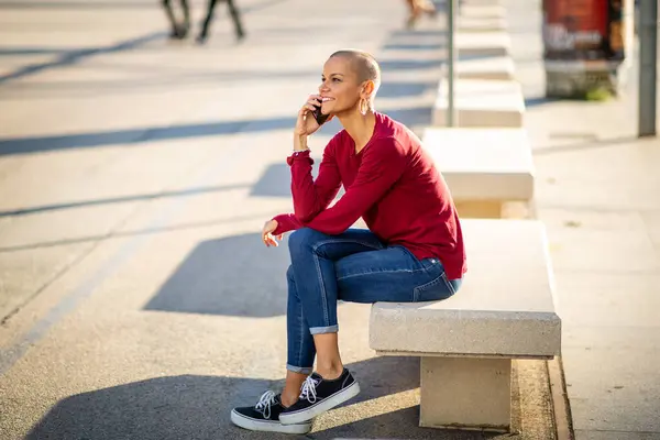 Şehirde oturup telefonla konuşan bir kadının portresi.