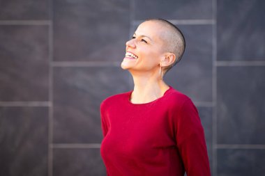 Tıraşlı, gülümseyen orta yaşlı bir kadının portresi.