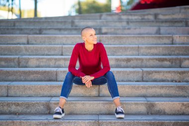 Kısa saçlı, basamaklarda oturan kadın portresi.