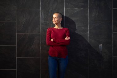 Kafası kazınmış bir kadının portresi duvarın yanında duruyor.