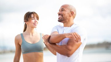 Fitness ikilisi dışarıda esneme egzersizleri yapıyor, enerji yayıyor, pozitiflik yayıyor ve sağlıklı yaşam için bağlılık sözü veriyor.