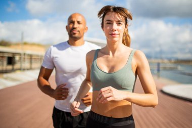 Açık havada koşan, kararlılık ve odaklanma saçan bir çiftin yakın plan görüntüsü.