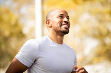 Kendinden emin ve atletik bir adam açık havada pozitif ışıldar, neşe ve sağlıklı bir yaşam tarzının göstergesidir..