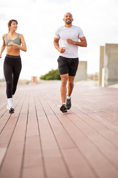 два любителя фитнеса бегать на открытом воздухе, охватывая свежий воздух и природную среду.