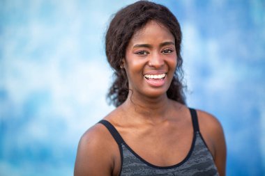 Mavi arka planda gülümseyen Afrikalı kadın portresi