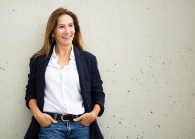 Gülümseyen portre ve duvarın karşısında duran cana yakın kadın.