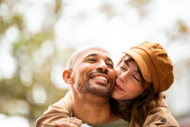 Gülümseyen çift, kadın eşinin sırtına binerken kaygısız bir anın tadını çıkarır.