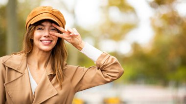 Gülümseyen genç bir kadın. Yüzünde barış imzası var.