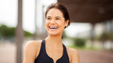 Kapıda duran gülümseyen Asyalı genç bir kadın.