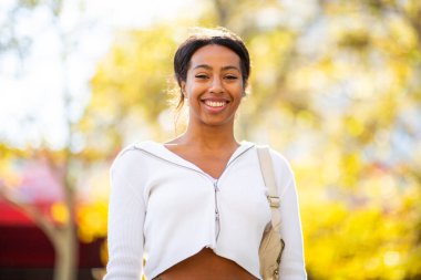 Gülümseyen genç siyah kadın sonbahar günü açık havada