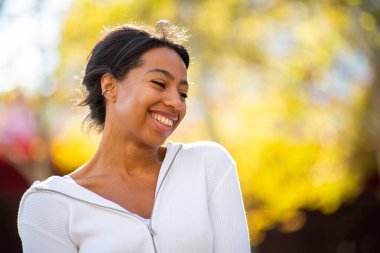 Gülümseyen genç İspanyol kadını sonbahar günü kapayın.