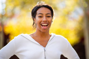 Neşeli kadın, açık hava portresine güvenle gülümsüyor.